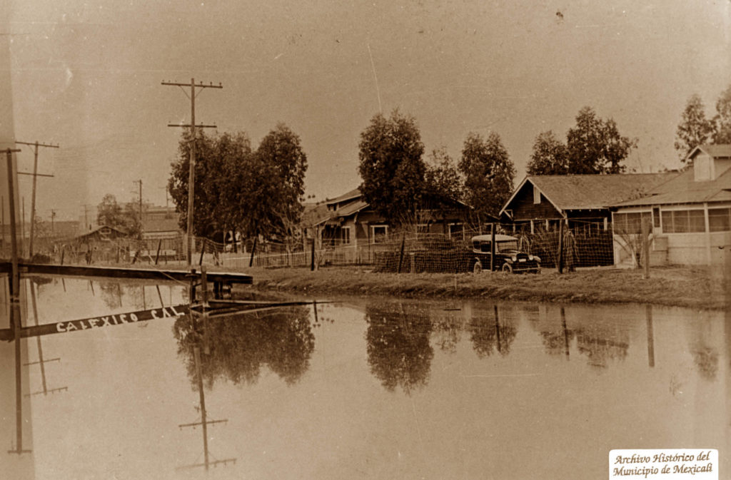 Vista de casas y fosa de almacenamiento de agua para uso doméstico en Calexico, 1920.